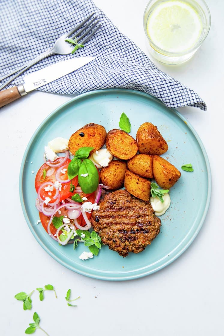 Grillet græsk hakkebøf med patatas bravas og tomatsalat