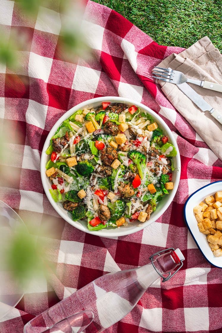 Pastasalat med kylling, broccoli og cæsardressing, toppet med urtecroutoner