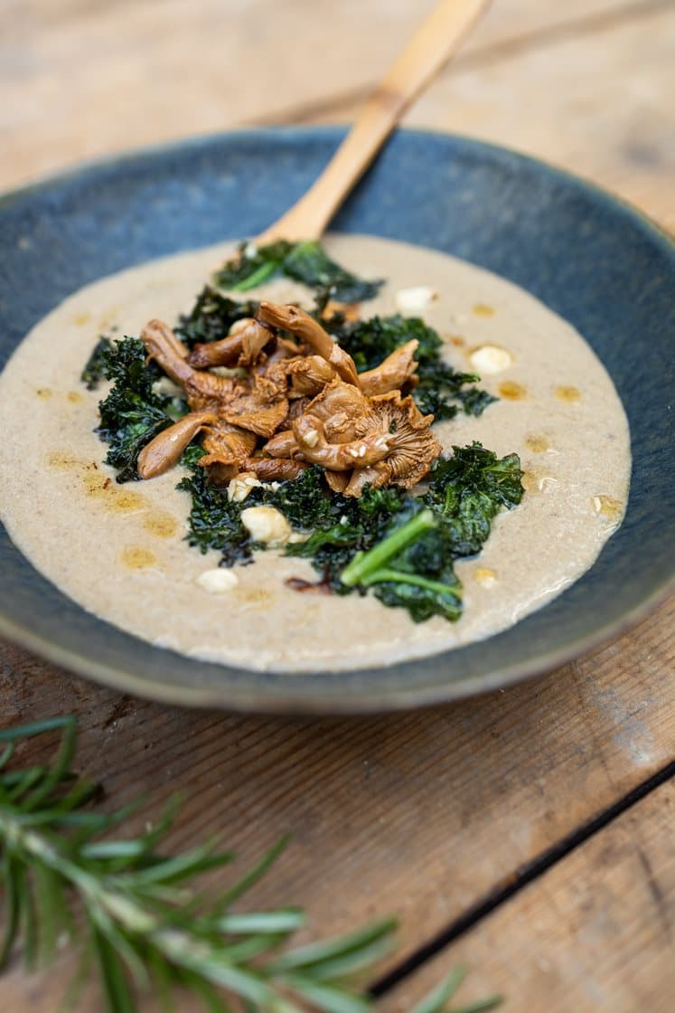 Svampesuppe toppet med smørstegte kantareller, sprød grønkål og hasselnødder