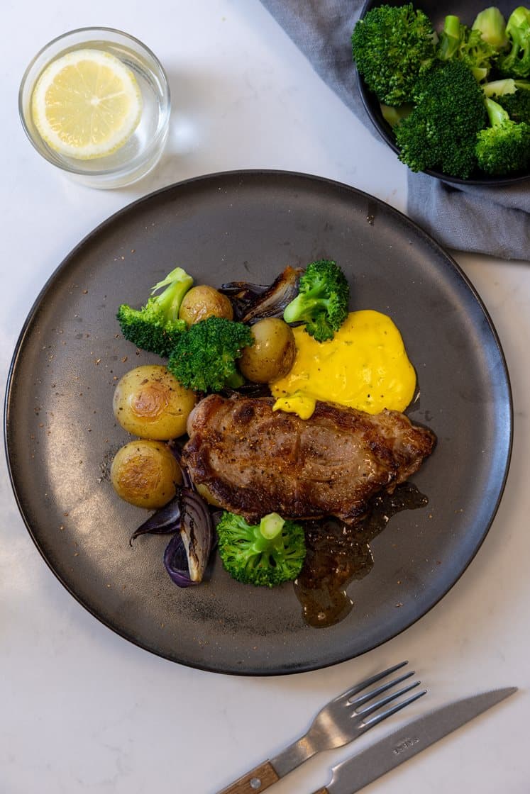 Citruskrydrede koteletter med ovnbagte kartofler, løg, broccoli og bearnaisesauce