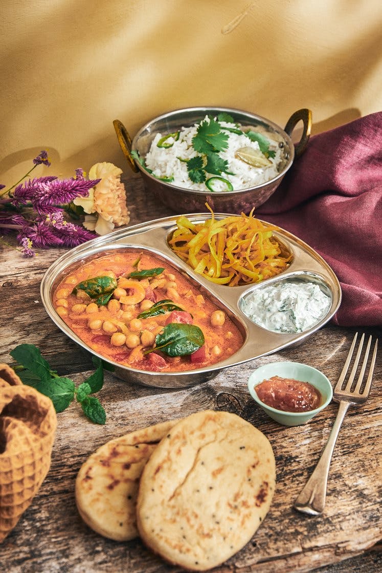 Indisk punjabi thali med chana masala, pulao og raita